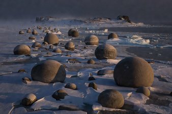 Mysterious spherical stone concretions sitting on the frozen shoreline of Champ Island