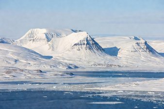 Snow-covered plateau mountains over Longyearbyen fjord in Svalbard
